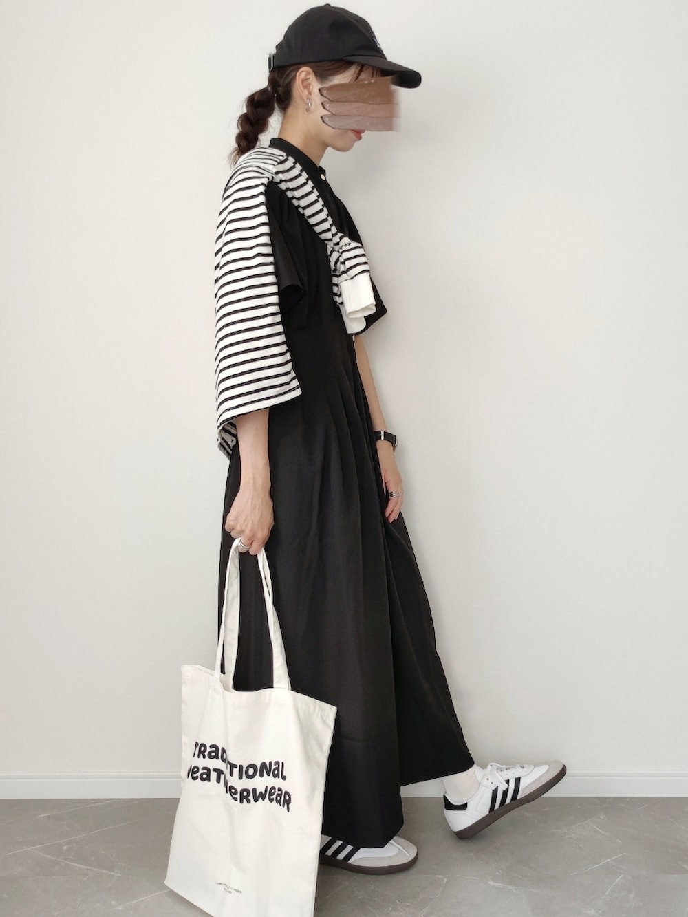 ブラック系のワンピース、ブルー系のトートバッグ、ホワイト系のスニーカーを着用したレディースの夏コーディネートの2枚目の写真