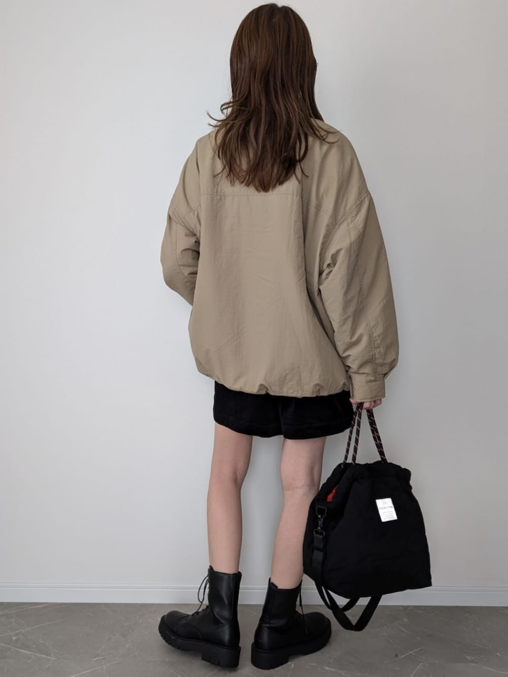 ベージュ系のブルゾン、ブラック系のその他パンツ、ブラック系のトートバッグを着用したレディースの秋コーディネートの2枚目の写真