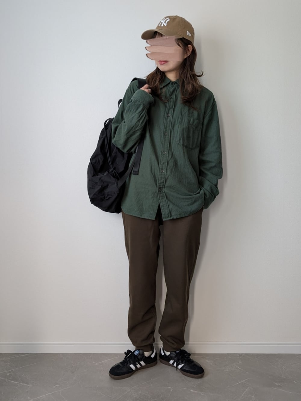 ブラウン系のスウェットパンツ、グリーン系のシャツ/ブラウス、ブラック系のバックパック/リュックを着用したレディースの冬コーディネートの3枚目の写真