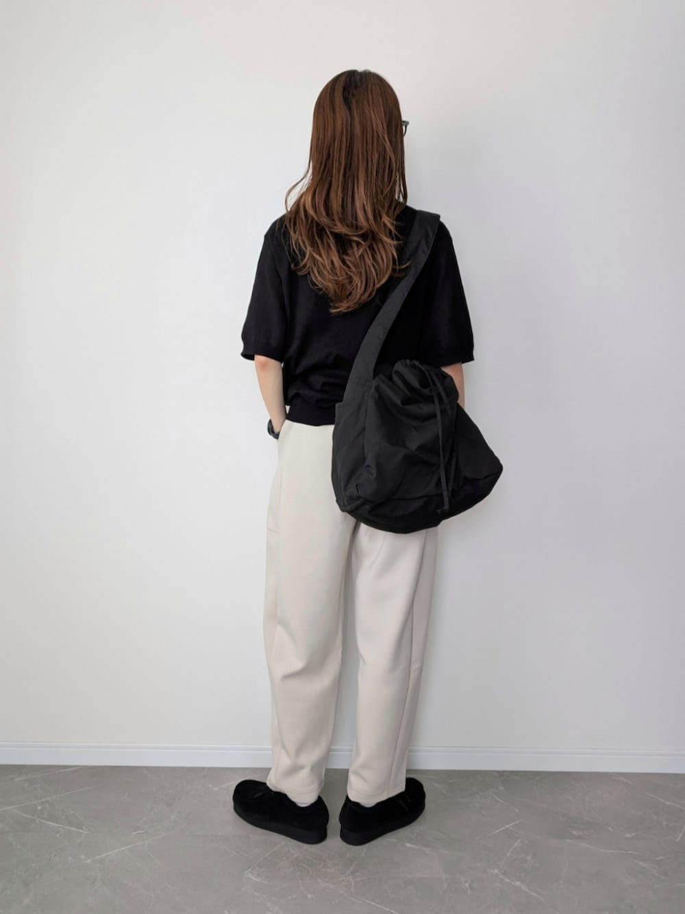 ホワイト系のスウェットパンツ、ブラック系のポロシャツ、ブラック系のショルダーバッグを着用したレディースの夏コーディネートの2枚目の写真