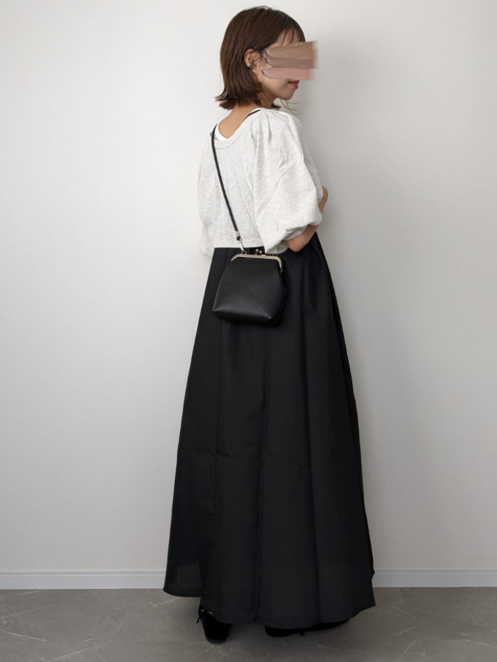 ベージュ系のワンピース、ブラック系のショルダーバッグ、ブラック系のパンプスを着用したレディースの夏コーディネートの3枚目の写真