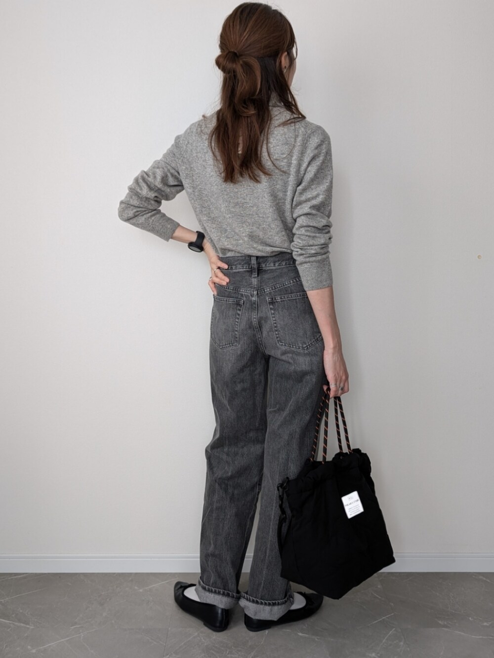 ブラック系のトートバッグ、グレー系のデニムパンツ、ブラック系のバレエシューズを着用したレディースの秋コーディネートの2枚目の写真