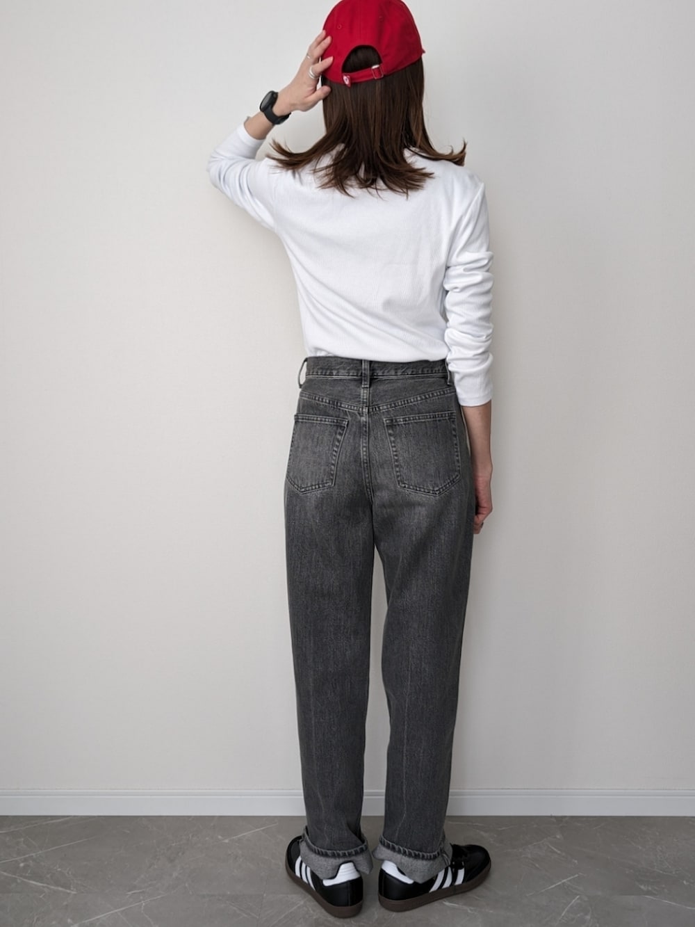 グレー系のデニムパンツ、ホワイト系のTシャツ/カットソー、ブラック系のスニーカーを着用したレディースの春コーディネートの2枚目の写真