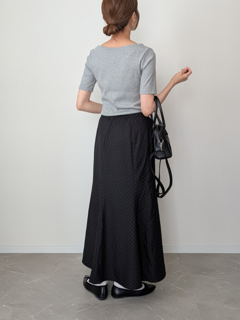 グレー系のTシャツ/カットソー、ブラック系のスカート、ブラック系のボストンバッグを着用したレディースの夏コーディネートの2枚目の写真