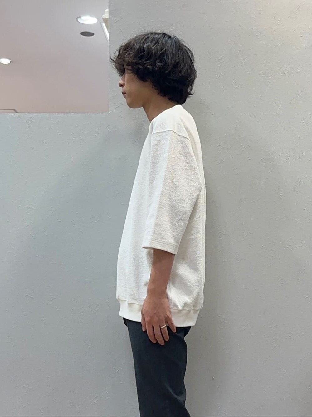 グレー系のスラックス、グレー系のクラッチバッグを着用したメンズの秋コーディネートの5枚目の写真