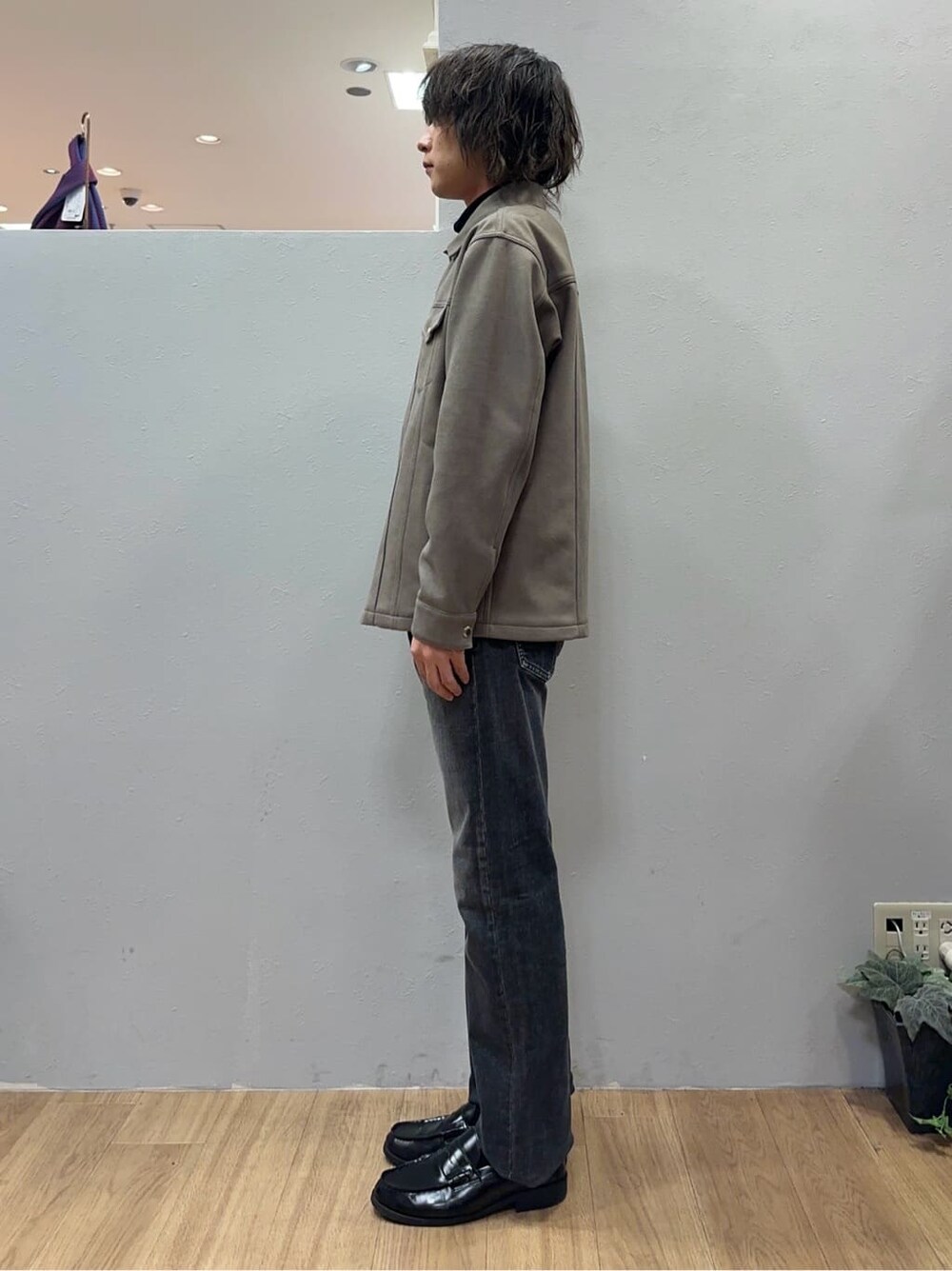 ベージュ系のブルゾン、ブラック系のニット/セーター、グレー系のデニムパンツを着用したメンズの秋コーディネートの3枚目の写真