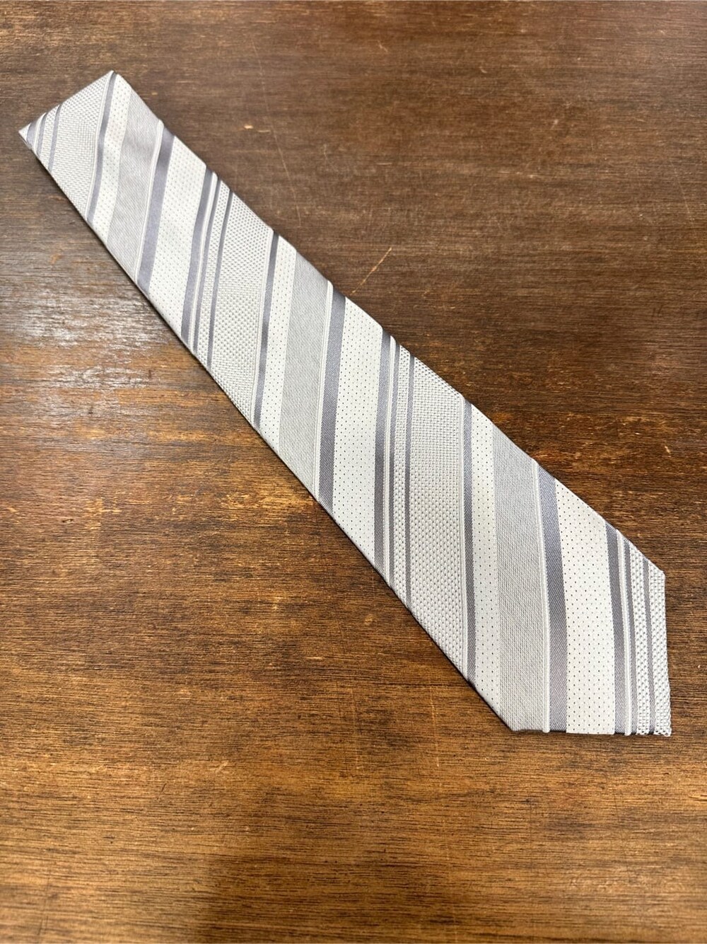 グレー系のネクタイ、グレー系のビジネスシャツ、ブルー系のスーツセットを着用したメンズの春コーディネートの4枚目の写真