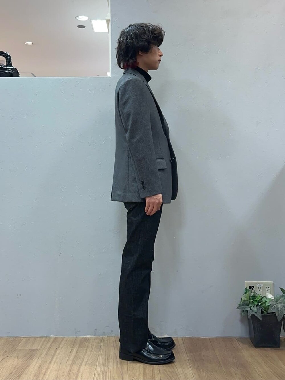 グレー系のテーラードジャケット、ブラック系のデニムパンツを着用したメンズの冬コーディネートの5枚目の写真