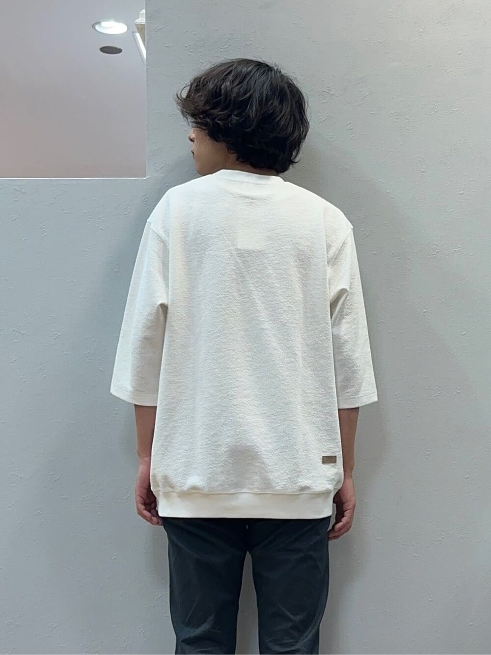 グレー系のスラックス、グレー系のクラッチバッグを着用したメンズの秋コーディネートの6枚目の写真