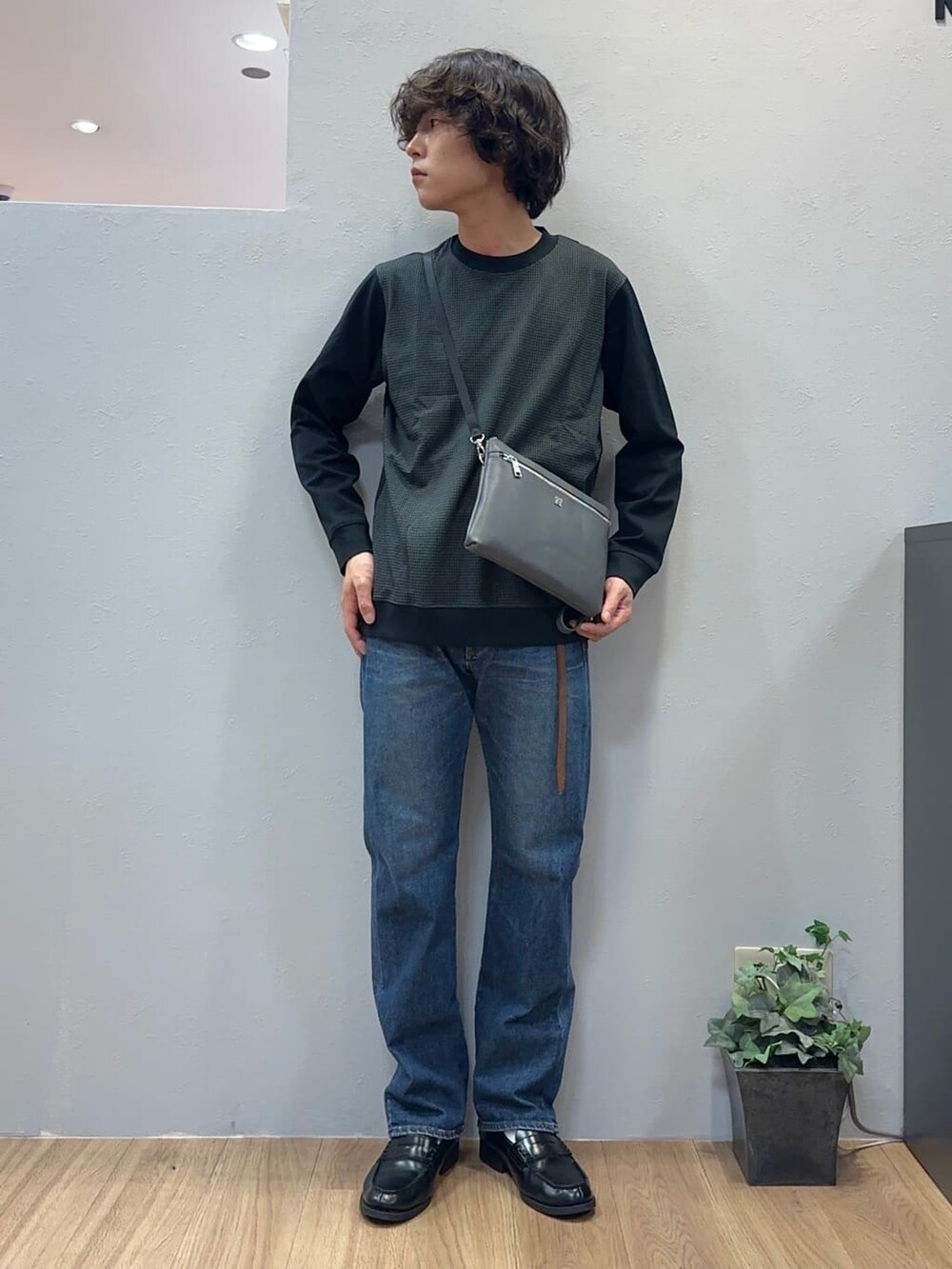 ブルー系のデニムパンツ、グレー系のクラッチバッグを着用したメンズの秋コーディネートの2枚目の写真