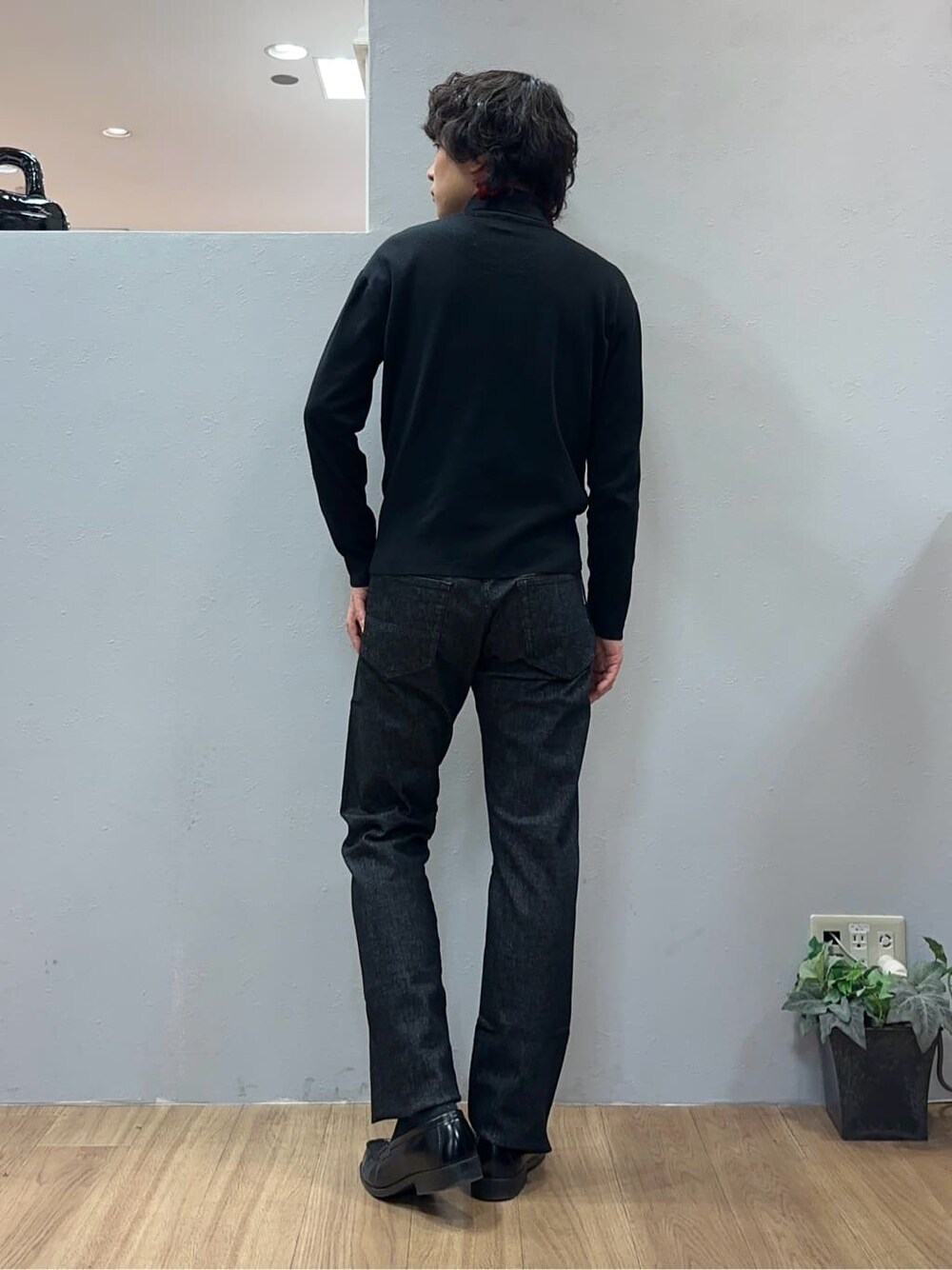 グレー系のチェスターコート、ブラック系のデニムパンツを着用したメンズの冬コーディネートの8枚目の写真