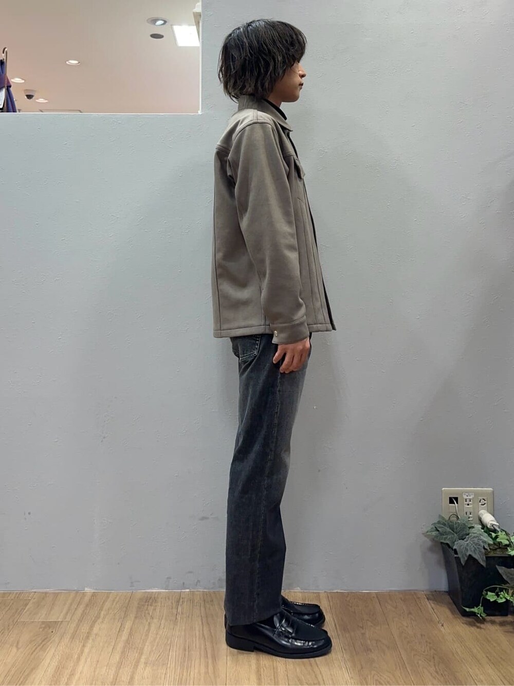 ベージュ系のブルゾン、ブラック系のニット/セーター、グレー系のデニムパンツを着用したメンズの秋コーディネートの5枚目の写真