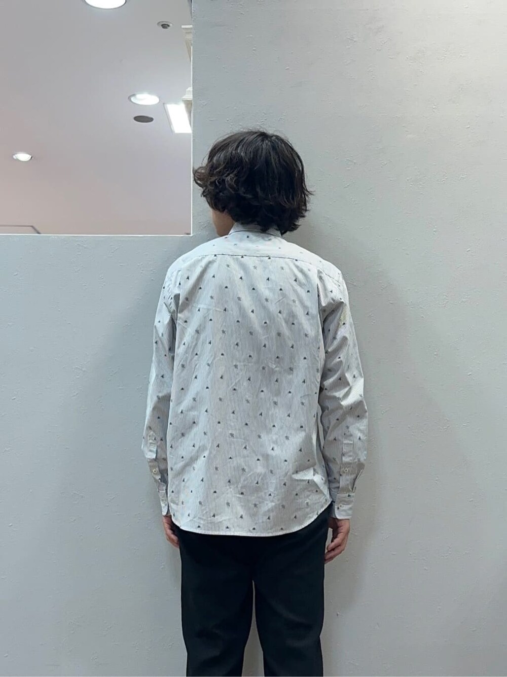 ブラック系のスラックス、グレー系のクラッチバッグを着用したメンズの秋コーディネートの6枚目の写真