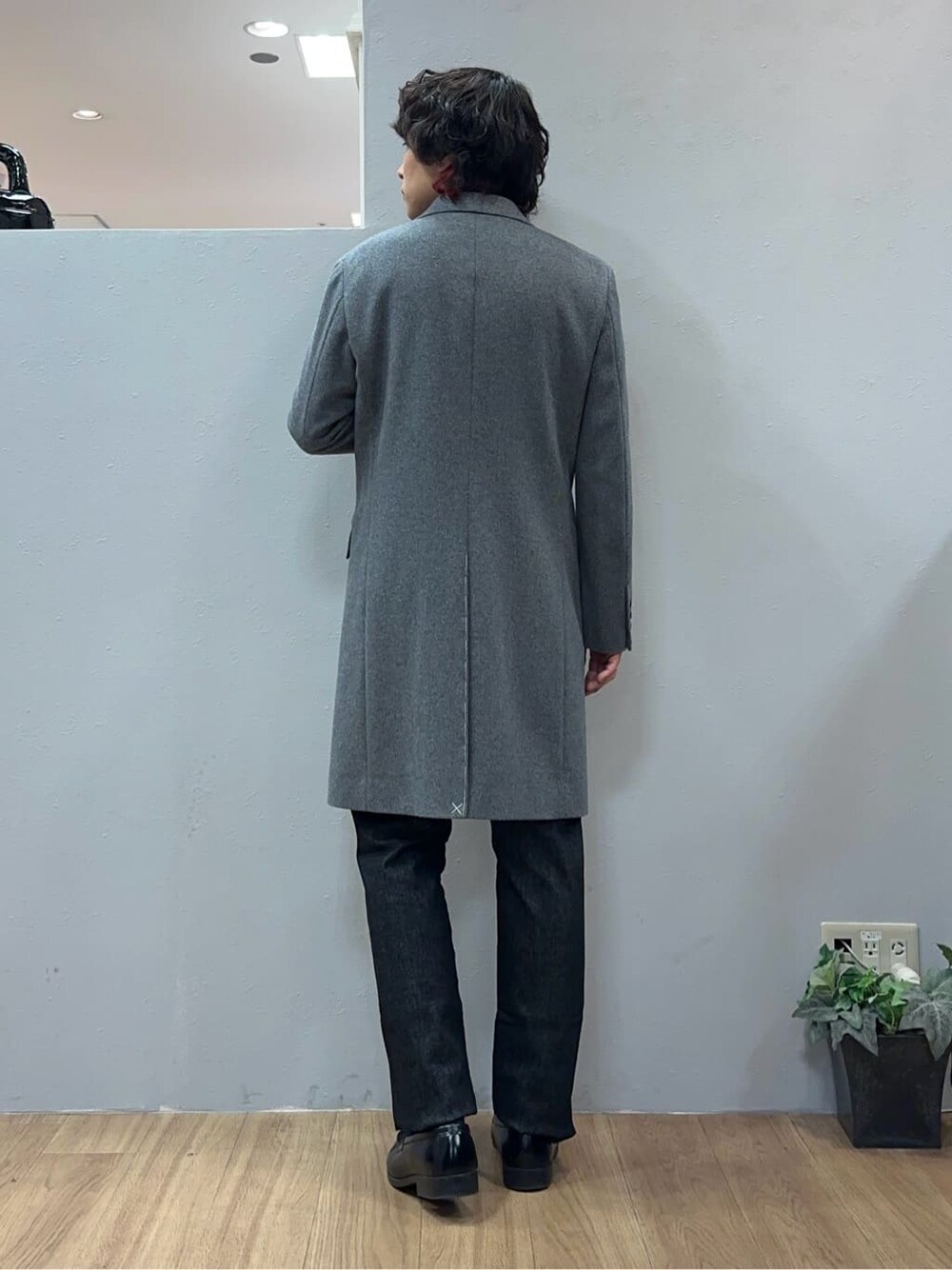 グレー系のチェスターコート、ブラック系のデニムパンツを着用したメンズの冬コーディネートの4枚目の写真