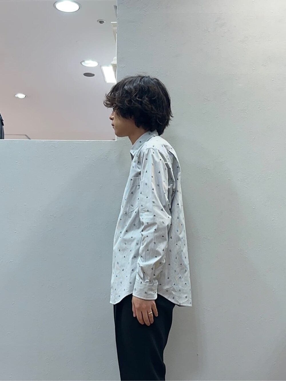 ブラック系のスラックス、グレー系のクラッチバッグを着用したメンズの秋コーディネートの5枚目の写真