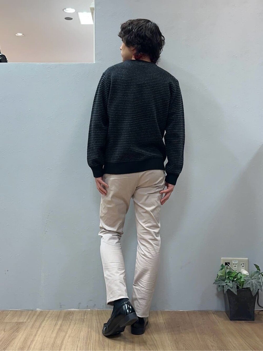 ベージュ系のスラックス、ブラック系のクラッチバッグを着用したメンズの冬コーディネートの6枚目の写真