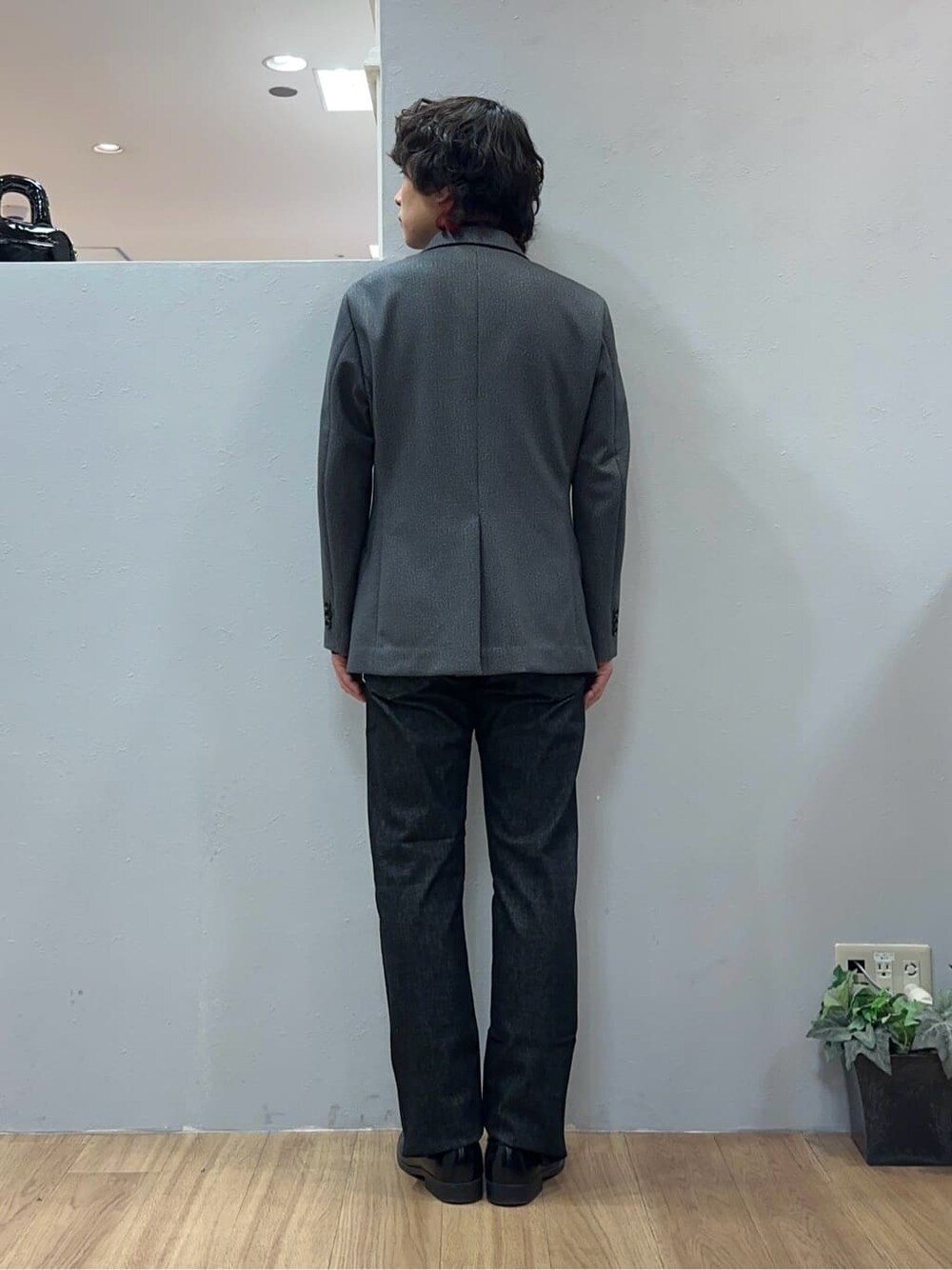 グレー系のテーラードジャケット、ブラック系のデニムパンツを着用したメンズの冬コーディネートの4枚目の写真