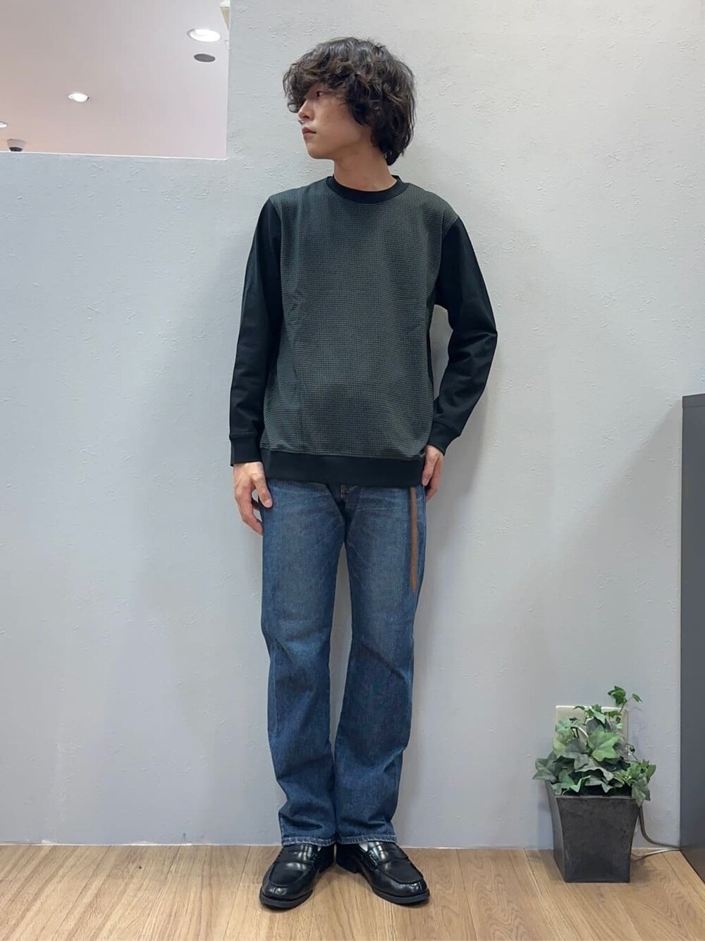 ブルー系のデニムパンツ、グレー系のクラッチバッグを着用したメンズの秋コーディネートの3枚目の写真