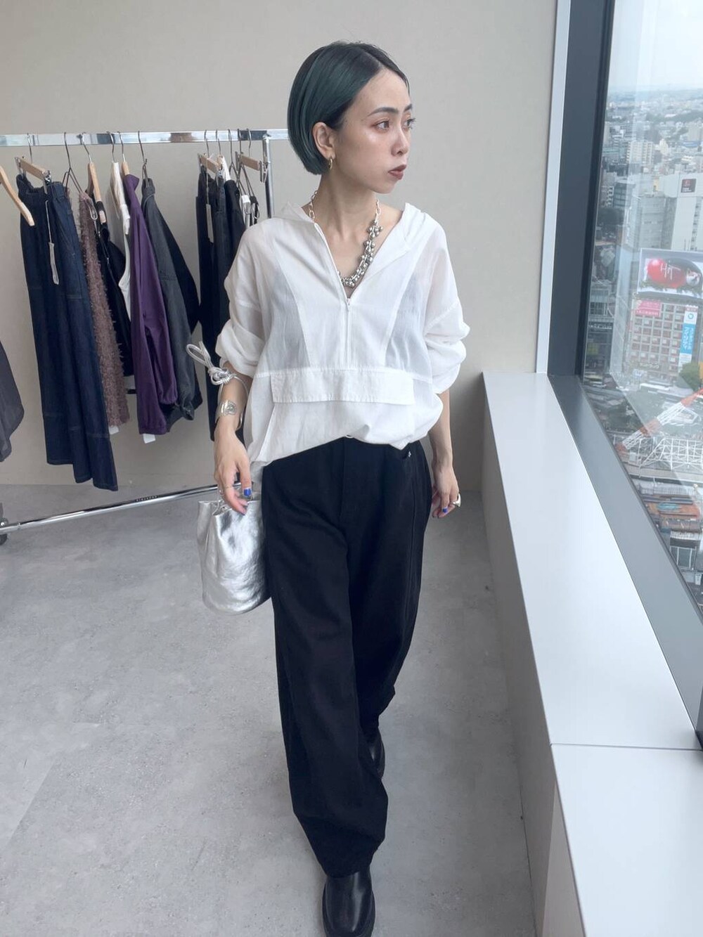 ブラック系のデニムパンツ、シルバー系のネックレスを着用したレディースの夏コーディネートの3枚目の写真