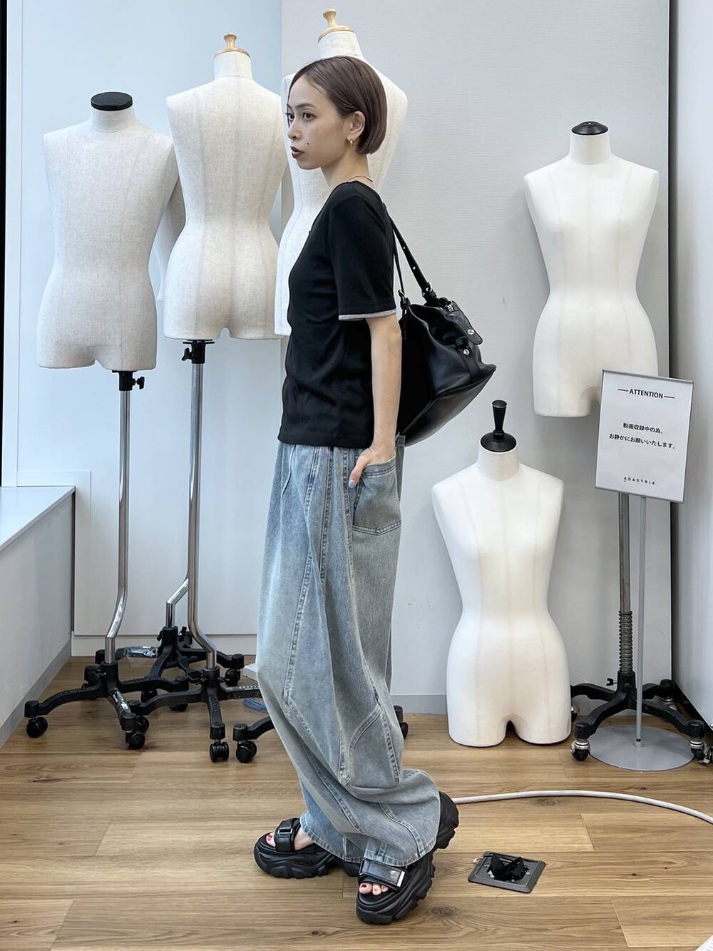 ブルー系のデニムパンツ、ブラック系のサンダル、ブラック系のボストンバッグを着用したレディースの春コーディネートの5枚目の写真