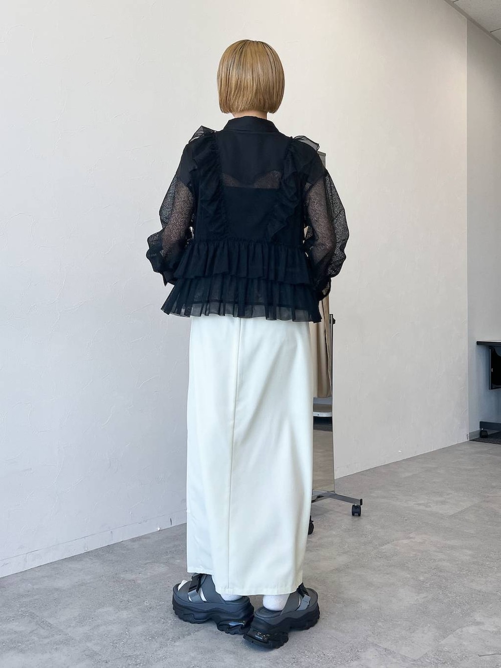 ブラック系のベスト、ブラック系のシャツ/ブラウス、ホワイト系のスカートを着用したレディースの春コーディネートの5枚目の写真