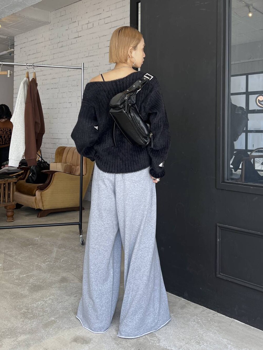 ブラック系のスニーカー、グレー系のスウェットパンツ、ブラック系のニット/セーターを着用したレディースの秋コーディネートの4枚目の写真