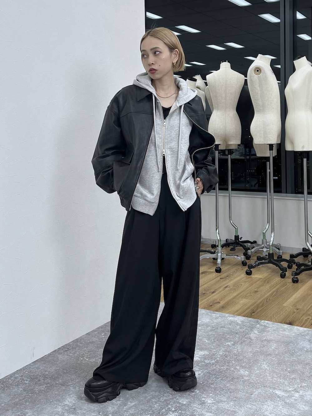 ブラック系のブーツ、ブラック系のスラックス、ブラック系のブルゾンを着用したレディースの秋コーディネートの7枚目の写真