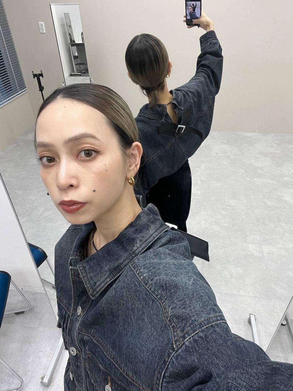 ブラック系のショルダーバッグ、ブルー系のデニムジャケット、ブラック系のその他パンツを着用したレディースの秋コーディネートの2枚目の写真