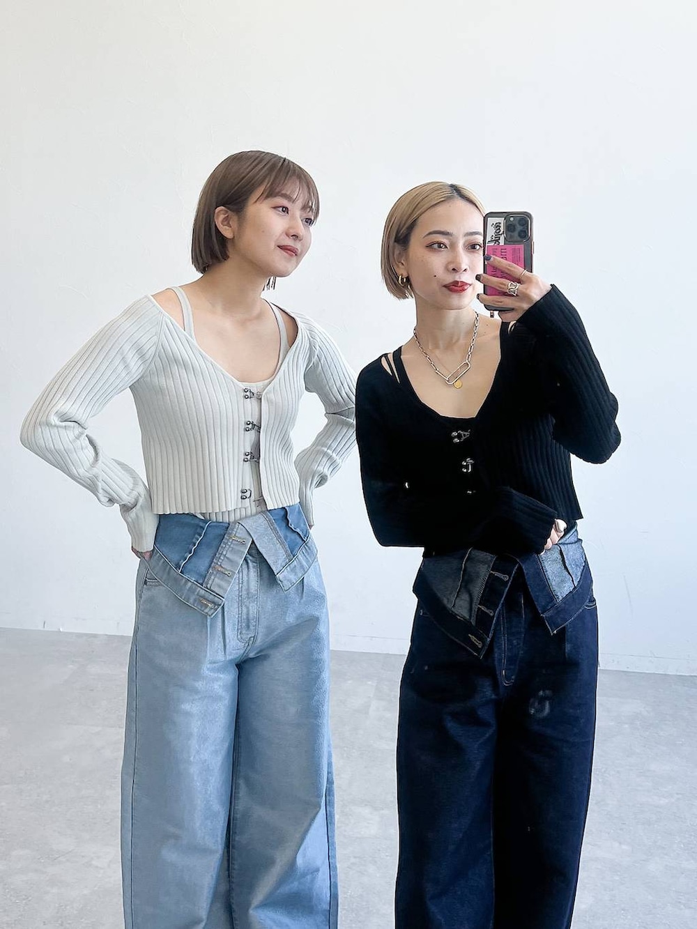 ブルー系のデニムパンツ、ブラック系のニット/セーター、グレー系のサンダルを着用したレディースの春コーディネートの2枚目の写真