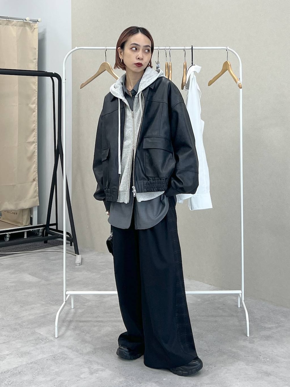 ブラック系のスニーカー、ブラック系のスラックス、ブラック系のハンドバッグを着用したレディースの秋コーディネートの3枚目の写真