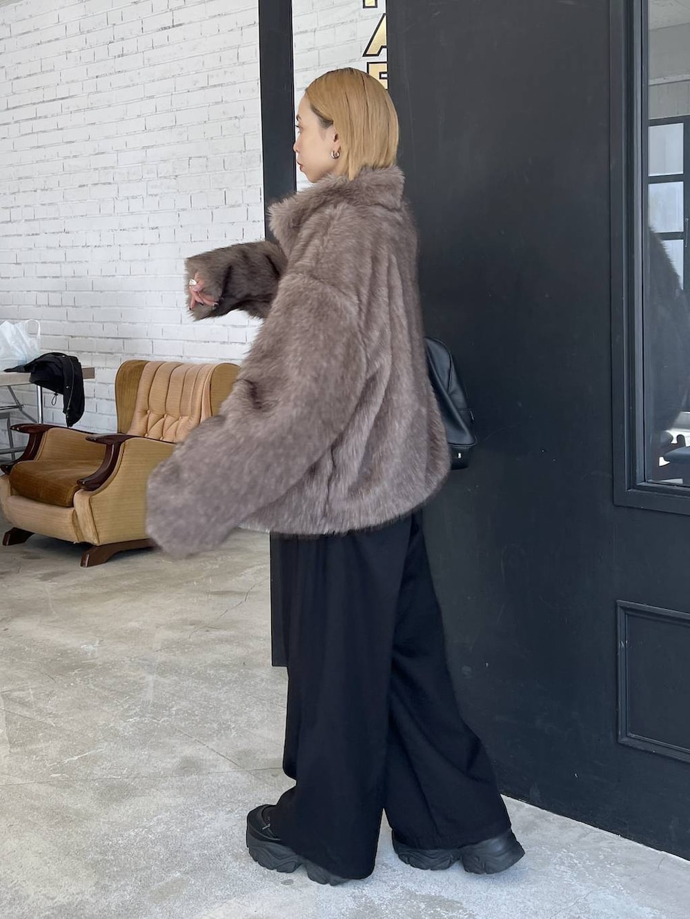 ブラック系のショルダーバッグ、ブラウン系のブルゾンを着用したレディースの秋コーディネートの3枚目の写真