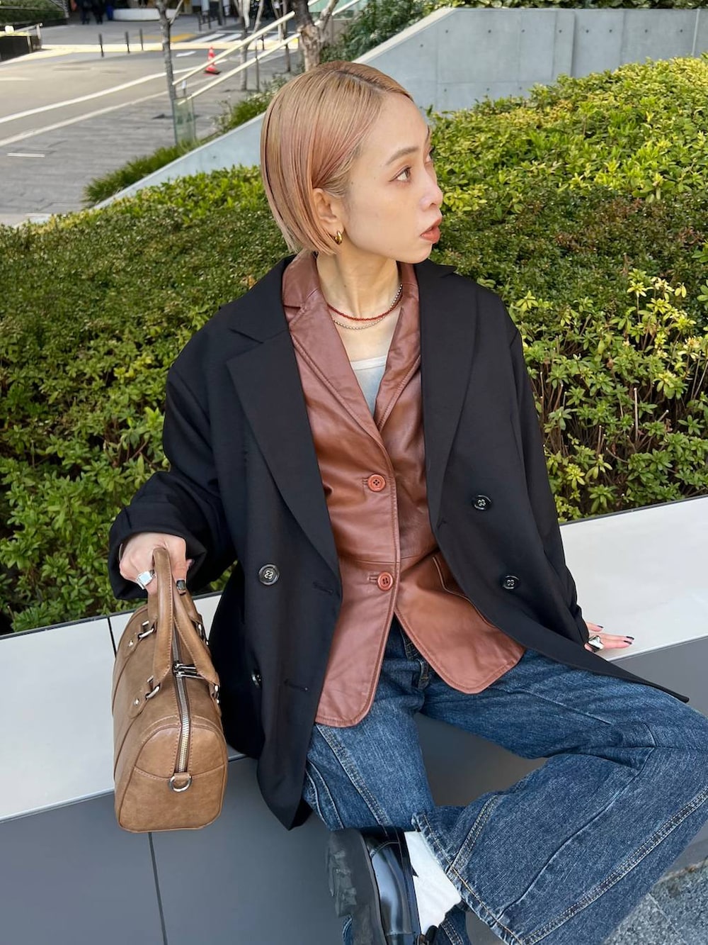 ブルー系のデニムパンツ、ブラウン系のボストンバッグ、ブラック系のテーラードジャケットを着用したレディースの春コーディネートの6枚目の写真