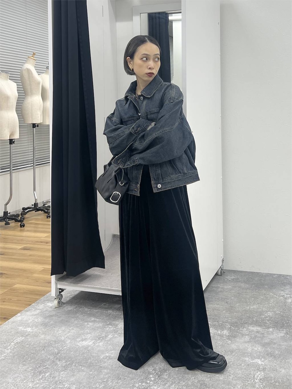 ブラック系のブーツ、ブルー系のデニムジャケット、ブラック系のショルダーバッグを着用したレディースの秋コーディネートの7枚目の写真