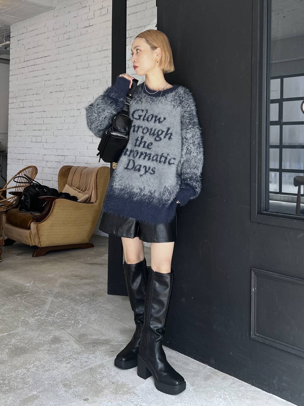 ブラック系のブーツ、ブルー系のニット/セーター、ブラック系のその他パンツを着用したレディースの秋コーディネートの2枚目の写真