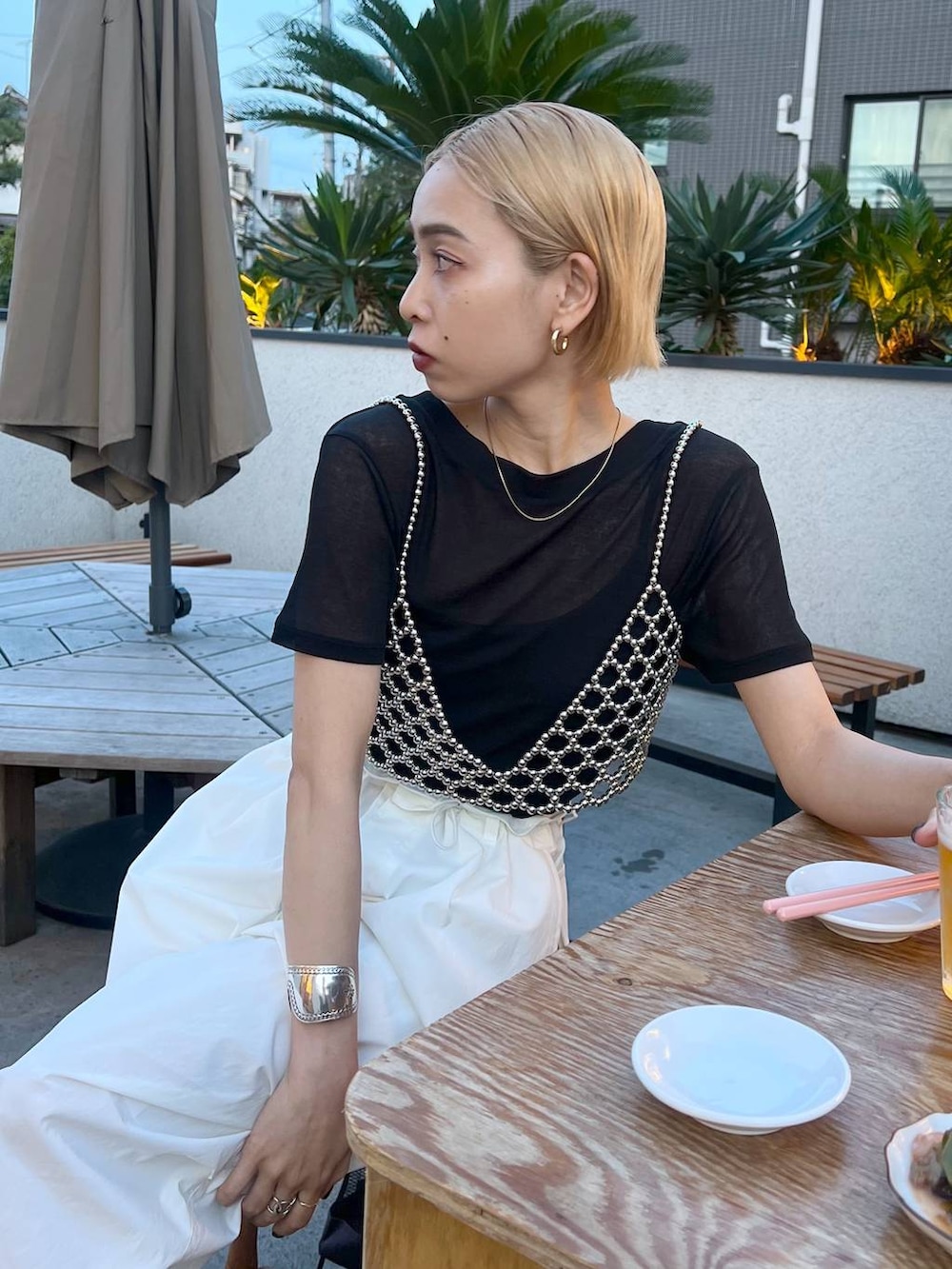ブラック系のTシャツ/カットソー、シルバー系のベスト、ホワイト系のカーゴパンツを着用したレディースの春コーディネートの4枚目の写真