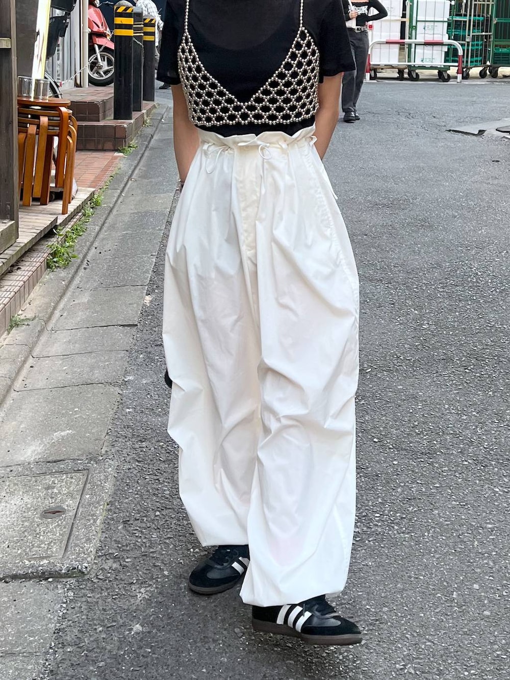 ブラック系のTシャツ/カットソー、シルバー系のベスト、ホワイト系のカーゴパンツを着用したレディースの春コーディネートの2枚目の写真