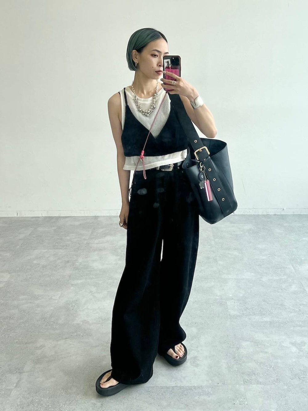 ブラック系のデニムパンツ、ブラック系のショルダーバッグ、ホワイト系のTシャツ/カットソーを着用したレディースの夏コーディネートの2枚目の写真