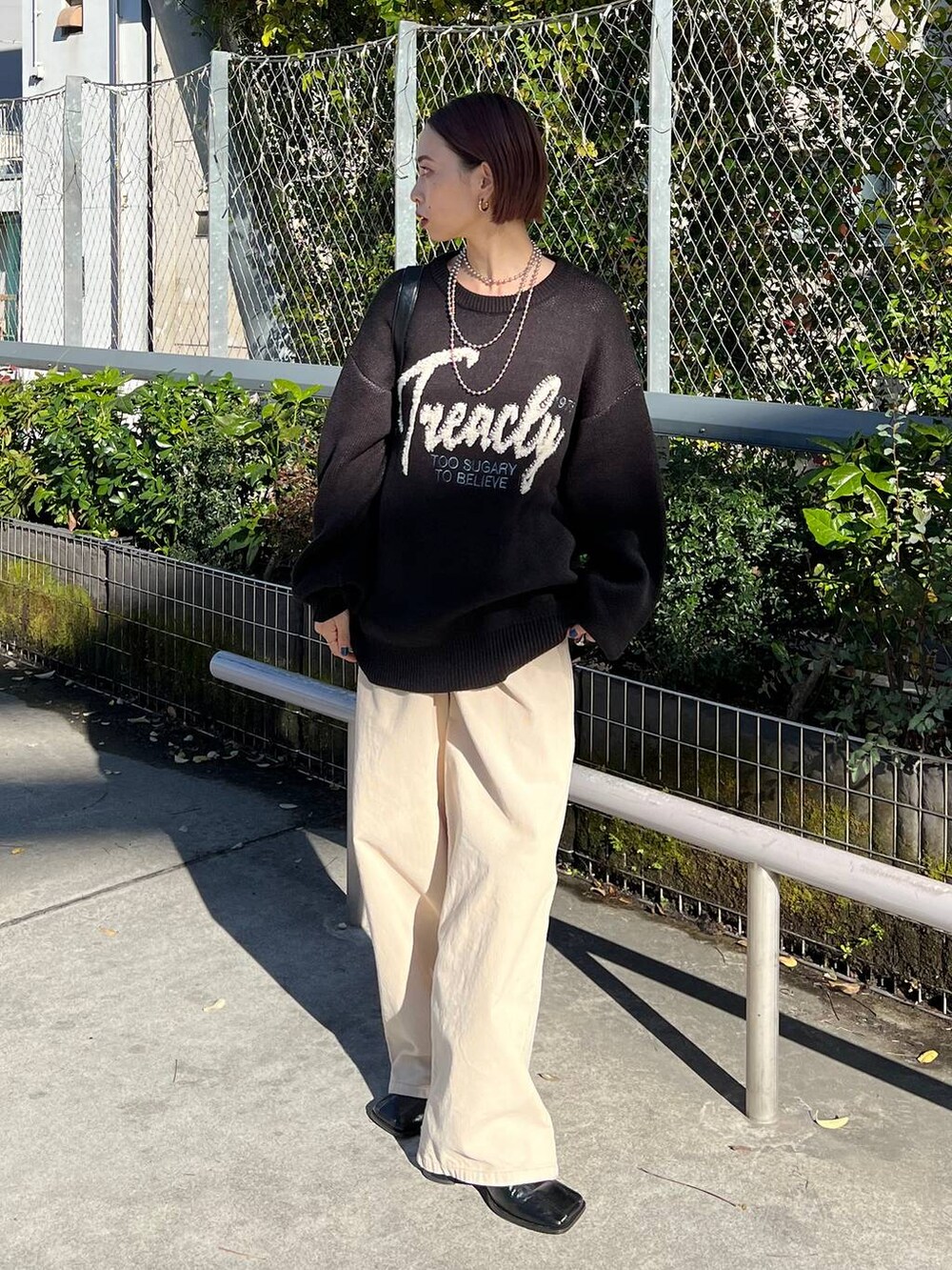 ブラック系のショルダーバッグ、ブラック系のブーツ、ブラック系のニット/セーターを着用したレディースの冬コーディネートの4枚目の写真