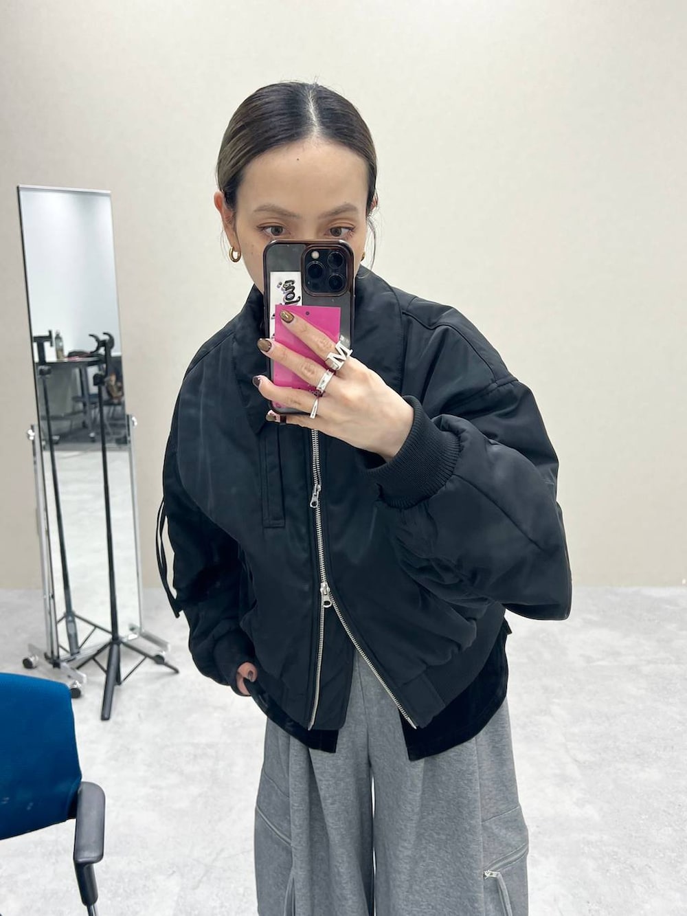 ブラック系のショルダーバッグ、グレー系のスウェットパンツ、ブラック系のMA-1を着用したレディースの秋コーディネートの3枚目の写真
