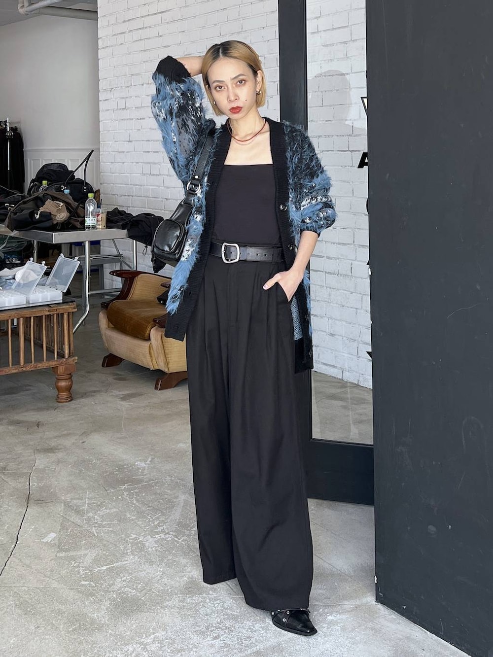 ブラック系のパンプス、ブルー系のカーディガン/ボレロ、ブラック系のショルダーバッグを着用したレディースの秋コーディネートの2枚目の写真