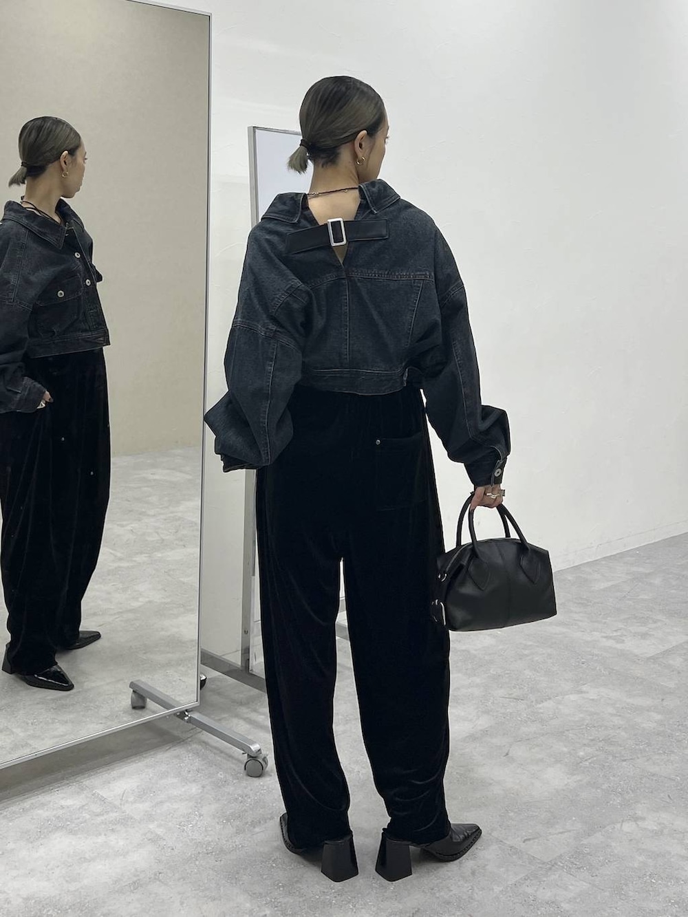 ブラック系のショルダーバッグ、ブルー系のデニムジャケット、ブラック系のその他パンツを着用したレディースの秋コーディネートの5枚目の写真