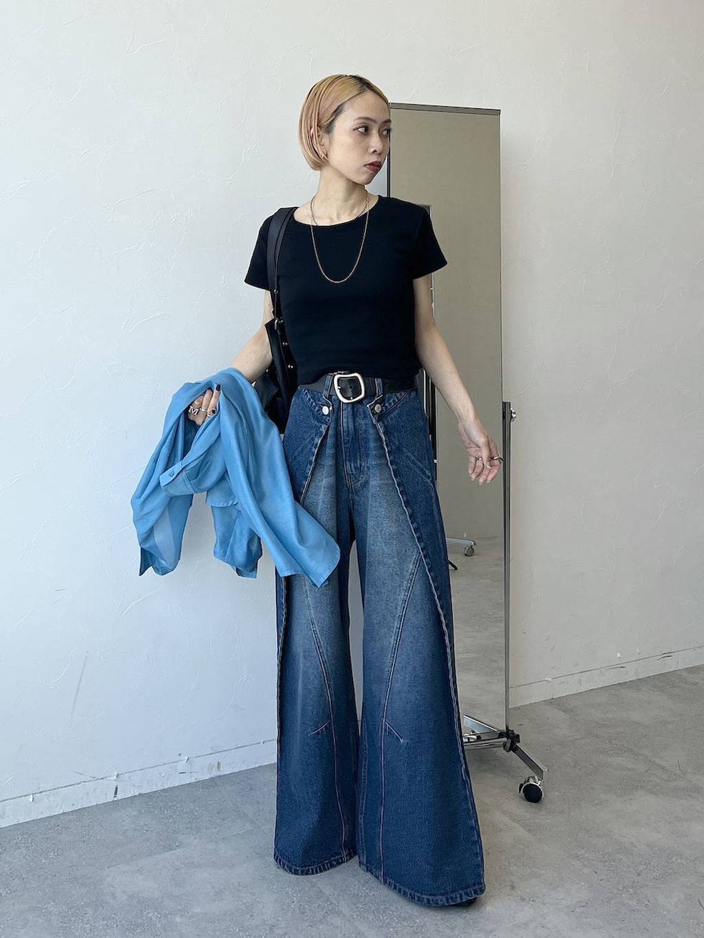 ブルー系のシャツ/ブラウス、ブラック系のTシャツ/カットソー、ブルー系のデニムパンツを着用したレディースの春コーディネートの4枚目の写真