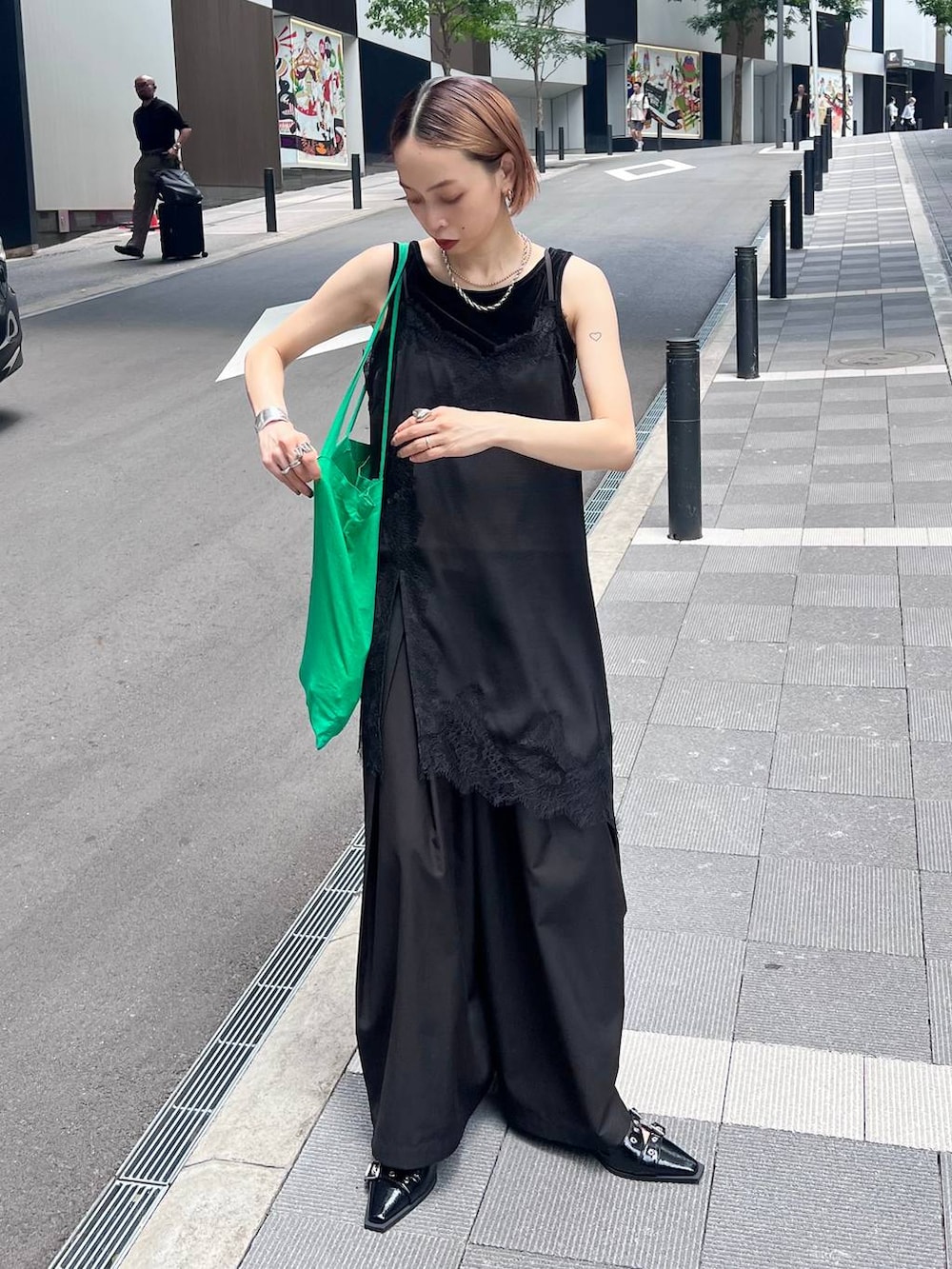 ブラック系のチュニック、ブラック系のスラックス、ブラック系のタンクトップを着用したレディースの夏コーディネートの2枚目の写真