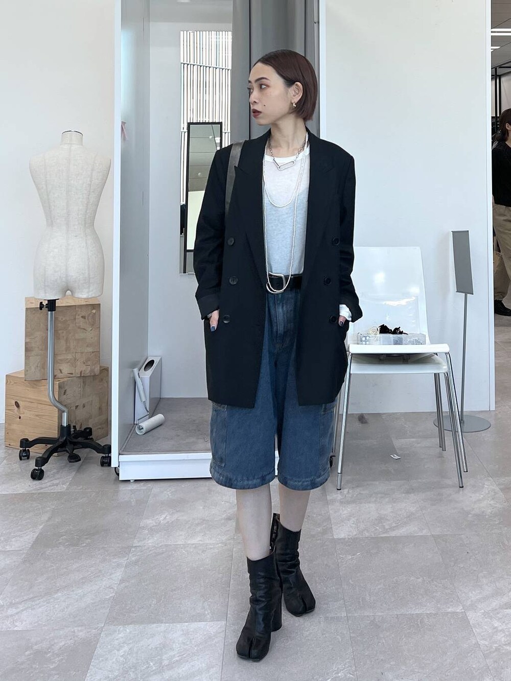 ブラック系のテーラードジャケット、その他のショルダーバッグ、ホワイト系のTシャツ/カットソーを着用したレディースの冬コーディネートの2枚目の写真