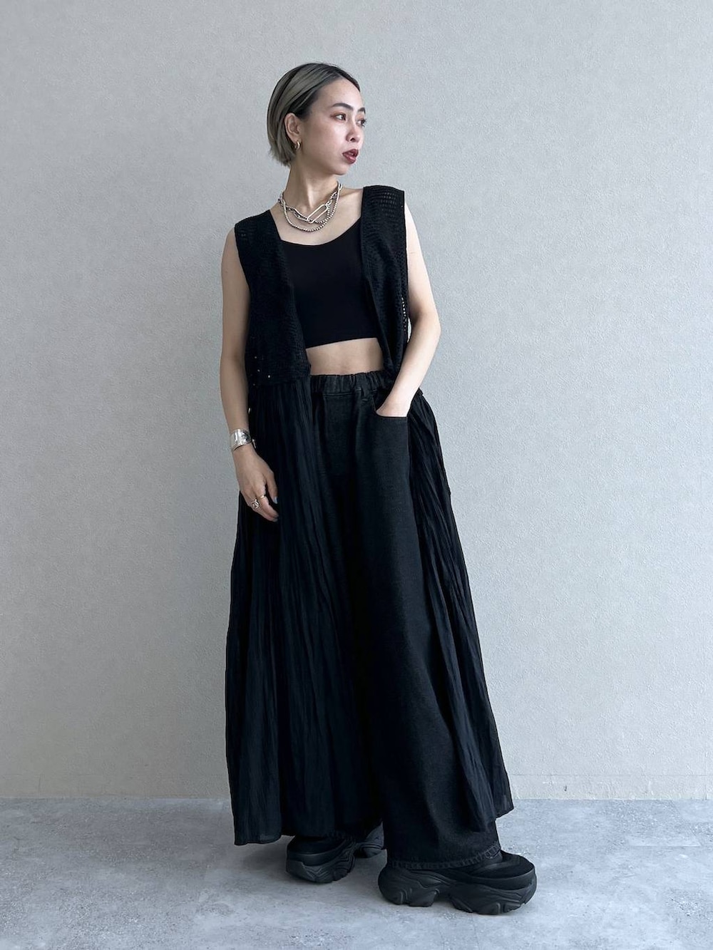 ブラック系のベスト、ブラック系のスニーカー、ブラック系のブラジャーを着用したレディースの夏コーディネートの2枚目の写真