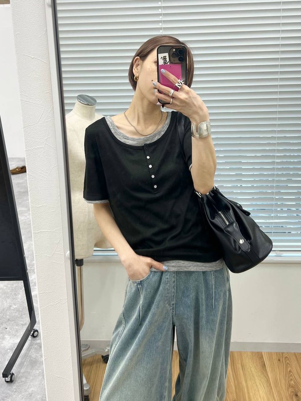 ブルー系のデニムパンツ、ブラック系のサンダル、ブラック系のボストンバッグを着用したレディースの春コーディネートの3枚目の写真