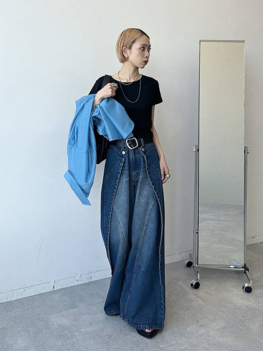 ブルー系のシャツ/ブラウス、ブラック系のTシャツ/カットソー、ブルー系のデニムパンツを着用したレディースの春コーディネートの2枚目の写真