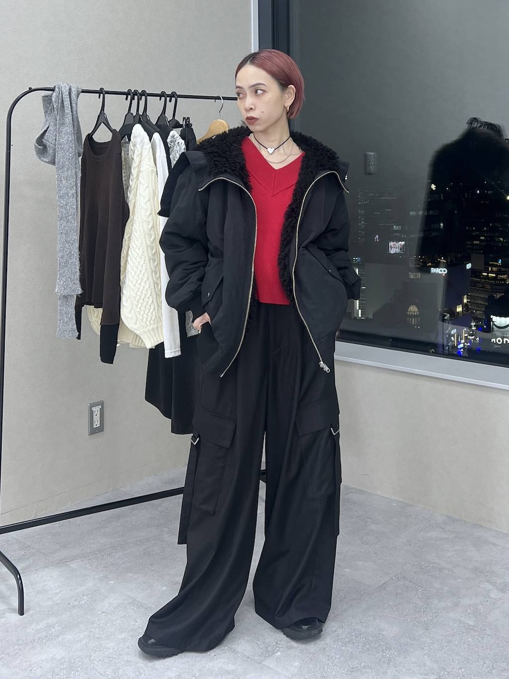 ブラック系のブルゾン、ブラック系のスラックス、レッド系のニット/セーターを着用したレディースの冬コーディネートの2枚目の写真