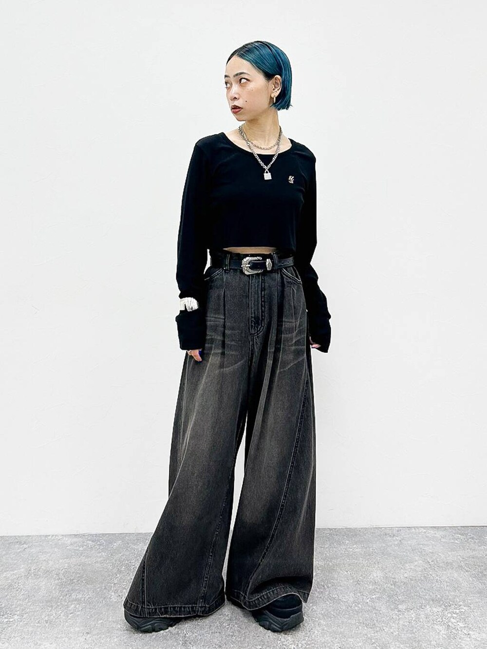 ブラック系のデニムパンツ、ブラック系のスニーカー、シルバー系のネックレスを着用したレディースの夏コーディネートの3枚目の写真