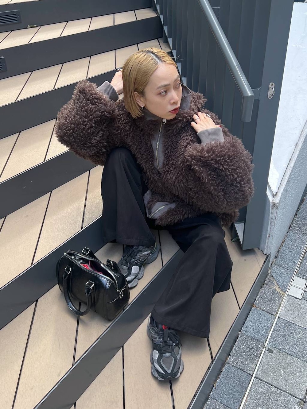 ブラウン系のブルゾン、ブラック系のニット/セーターを着用したレディースの秋コーディネートの5枚目の写真